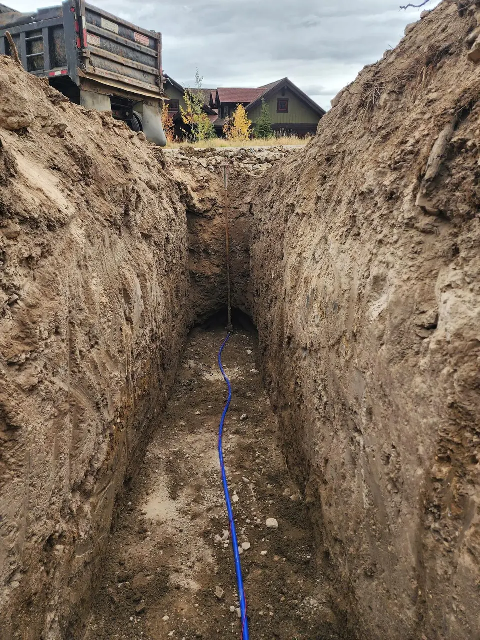 A deep, straight trench with a blue water line running along its floor